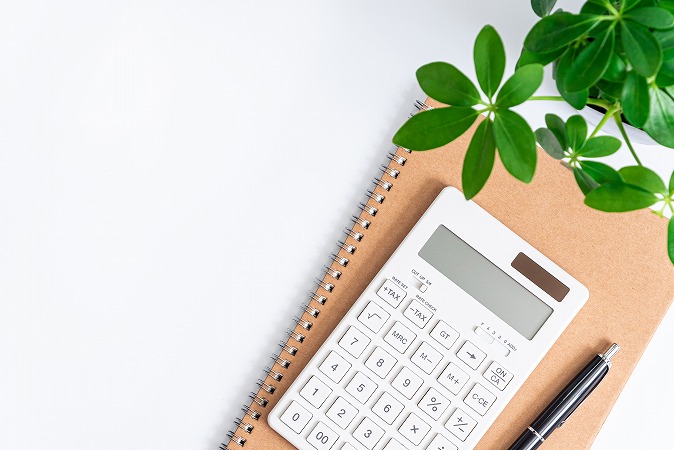 ノートの上に電卓とペン